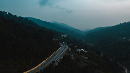 Aerial view of road in the middle of green mountains