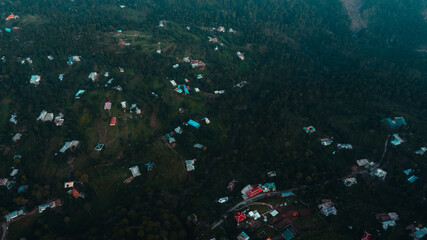 Aerial view of beautiful homes in green hills surrounded by trees 