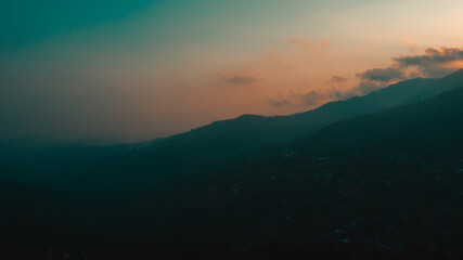 Silhouette of mountain under cloudy sky