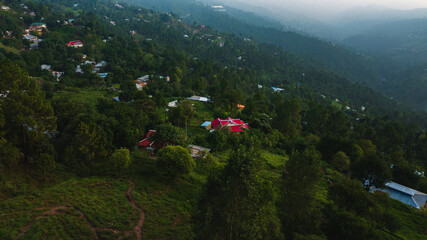 Aerial view of beautiful homes in green hills surrounded by trees 