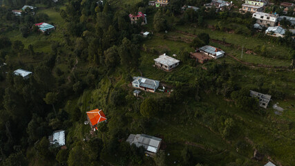 Aerial view of beautiful homes in green hills surrounded by trees 
