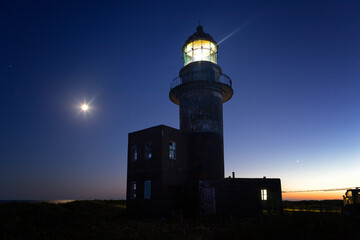 Working lighthouse and starry sky