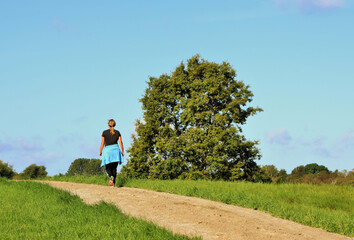 Woman in sportswear is walking along the path in the park on a summer dag. High quality photo