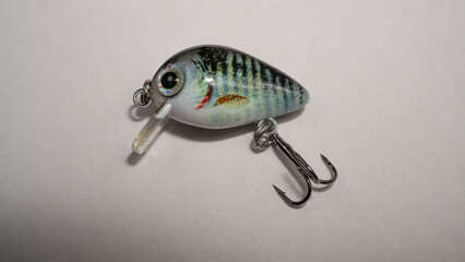 Closeup of bait for fishing in the shape of a mini wobbler with a hook on a white background