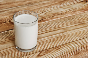 Glass of fresh milk on wooden table.