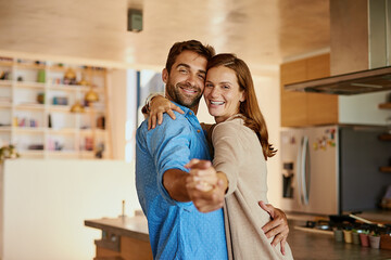 Let love lead. Cropped portrait of an affectionate young couple dancing in their kitchen.