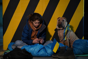 Young woman in the bomb shelter taking care of her dog