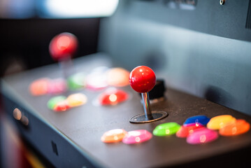 Selective focus shot of a red arcade joystick of a gaming machine in an office