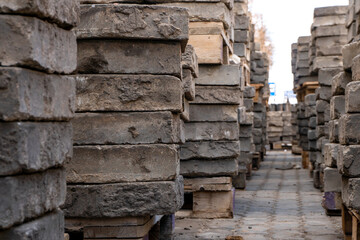 Old paving slabs in close-up. Storage of paving slabs during the repair of roads and pedestrian areas. Reconstruction of urban infrastructure.