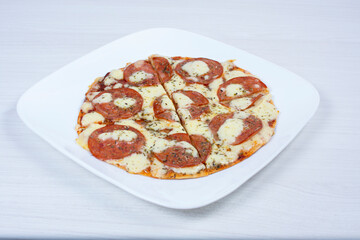 Traditional tomato, cheese, oregano pizza on red checkered napkin