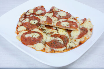 Traditional tomato, cheese, oregano pizza on red checkered napkin