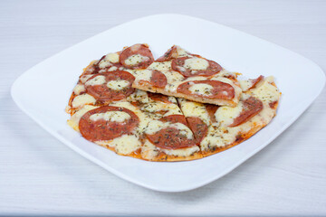 Traditional tomato, cheese, oregano pizza on red checkered napkin