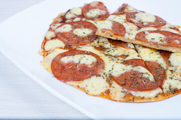 Traditional tomato, cheese, oregano pizza on red checkered napkin