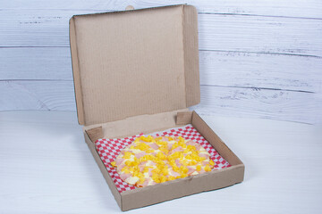 Traditional Hawaiian pizza, with cheese, pineapple, pomodoro pasta on checkered napkin