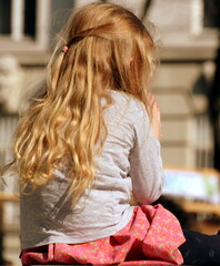 Kind mit langen blonden Haaren auf Beobachtungsposten die Welt beobachtend