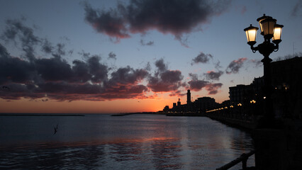 Bari, Lungomare, sorgere del sole nella bellissima città, silhouette profilo scuro nero, Sud,...