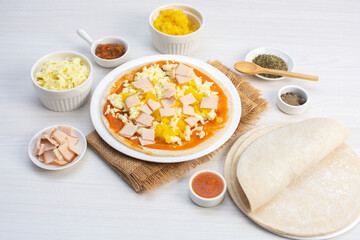 Artisan pizza before baking, with cheese, ham, pineapple, pomodoro sauce, accompanied by flavors