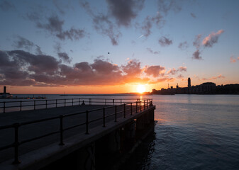 Bari, Lungomare vista dal molo di San Nicola, sorgere del sole nella bellissima città, silhouette...