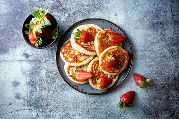 Fototapeta na wymiar Pancakes decorated with strawberries in a plate