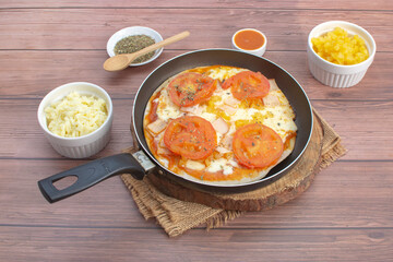 Artisan pizza before baking, with cheese, ham, pineapple, pomodoro sauce, accompanied by flavors