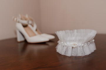 Fototapeta na wymiar White shoes and bridal garter. Bride morning. Bride's accessories