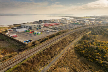 Aerial view on railroad to Galway city and bus repair and storage facility. Calm blue sky. Galway...