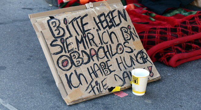 Schild auf einem B&uuml;rgersteig: "Bitte helfen sie mir. Ich bin obdachlos und habe Hunger. Vielen Dank."