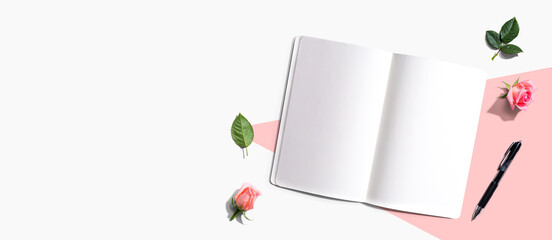 Open notebook or diary with a pen from above with rose buds- flat lay - Powered by Adobe