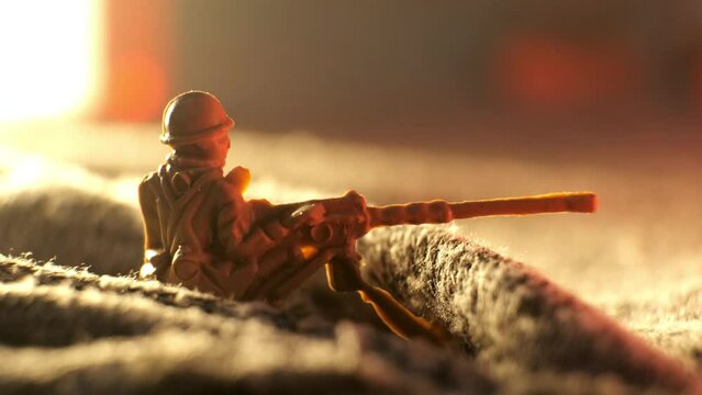 A toy soldier machine gunner shoots from a shelter in a trench. The concept of war on the battlefield