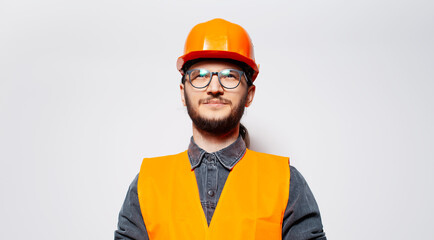 Studio portrait of young smiling construction worker on white. Looking up.