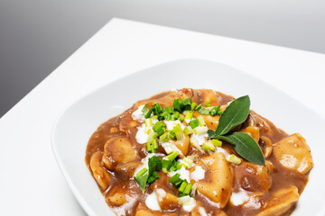 Vegan food. Homemade dumplings with potatoes and mushrooms in gravy. Close-up.