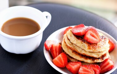 closeup pancakes with strawberries and cup of coffee food sweet breakfast dessert beverage