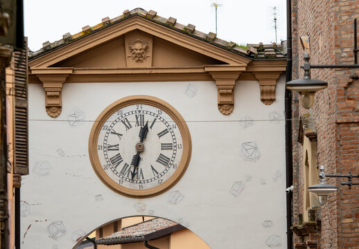 ancient clock on the arched entrance door to the city of Dozza, famous for its artistic murals, in the province of Bologna