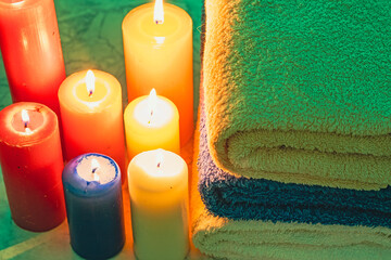 Obraz na płótnie Canvas Towels bent on top of each other with candles around 