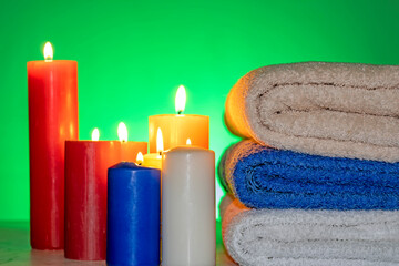 Obraz na płótnie Canvas Towels bent on top of each other with candles around 