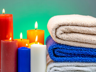 Fototapeta na wymiar Towels bent on top of each other with candles around 