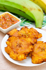 
Patacones or fried tostones of green or ripe plantain, with a crispy texture, accompanied by a tomato and onion stew called 