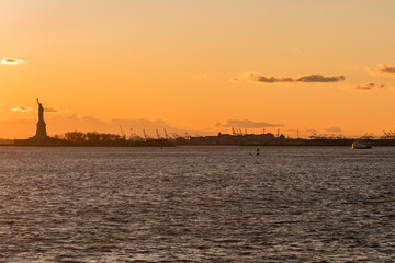 That Statue of Liberty and the cranes of the Port of Newark at sunset