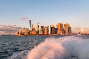 The financial district of New York City, New York, USA at sunset as seen from New York Harbor.