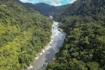 Fototapeta na wymiar Aerial view of a stunning mountain river with a granite rockbed surrounded by hills covered in tropical forest: a relaxing nature background from Ecuador, South america