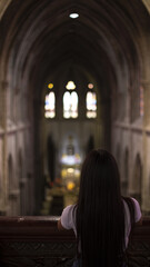 A woman with long black hair is looking over the church below