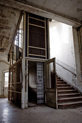 Vertical shot of the interior in an old abandoned building with an elevator and stairs