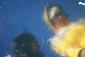 Teenage girl and mom are reflected in the dark ice of Lake Baikal