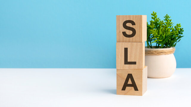 sla - word from wooden blocks with letters, blue background. copy space available
