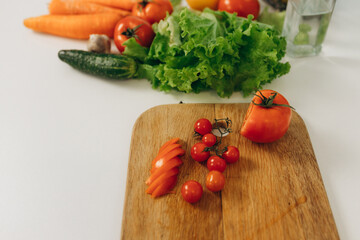 sliced ​​tomato on a kitchen board. Lots of vegetables on the table