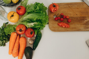 sliced ​​tomato on a kitchen board. Lots of vegetables on the table