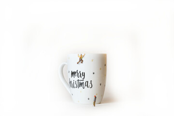 Closeup shot of miniature mountain climbers climbing on a cup with 'Merry Christmas' text
