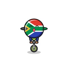 The cute south africa flag character is riding a circus bike