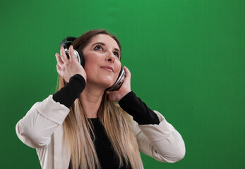 Young pretty woman listens to music on her headphones - studio photography