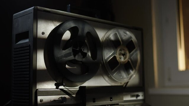 Start and stop play old reel tape recorder plays magnetic tape record. Front view of old vintage tape recorder. rays of sun fall on recorder. concept of detective or documentary.